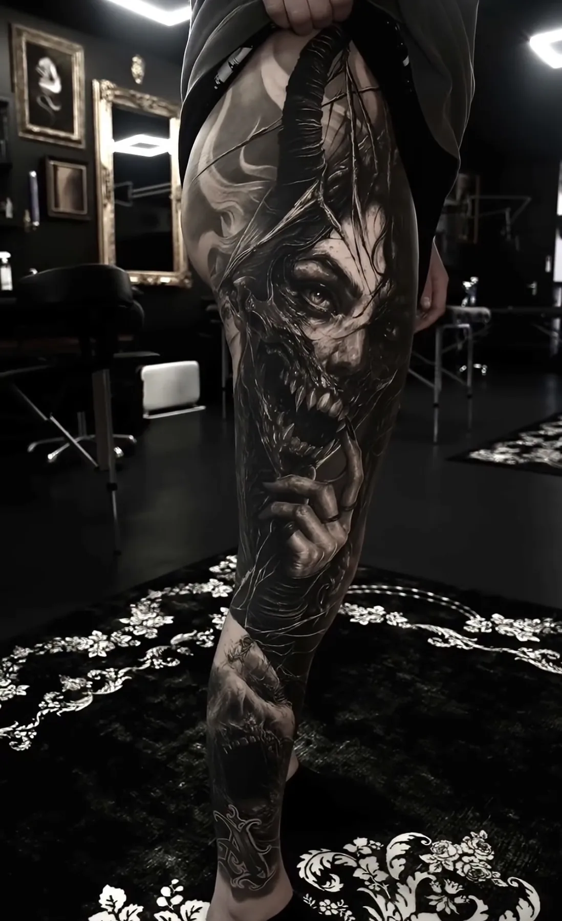 A full-leg tattoo of a skeletal creature surrounded by twisting forms.