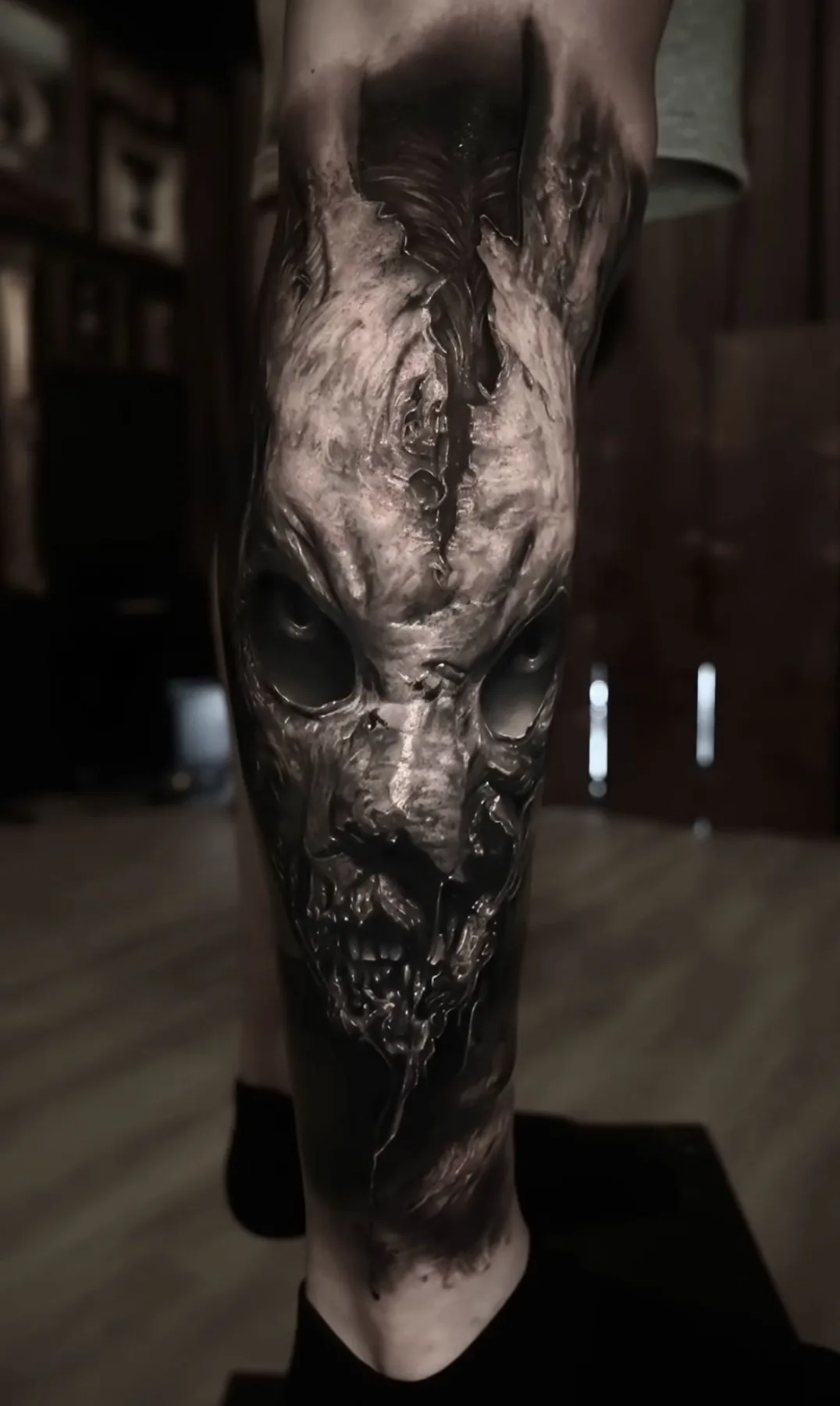 A black and grey tattoo of a skeletal creature with long ears and hollow eye sockets.