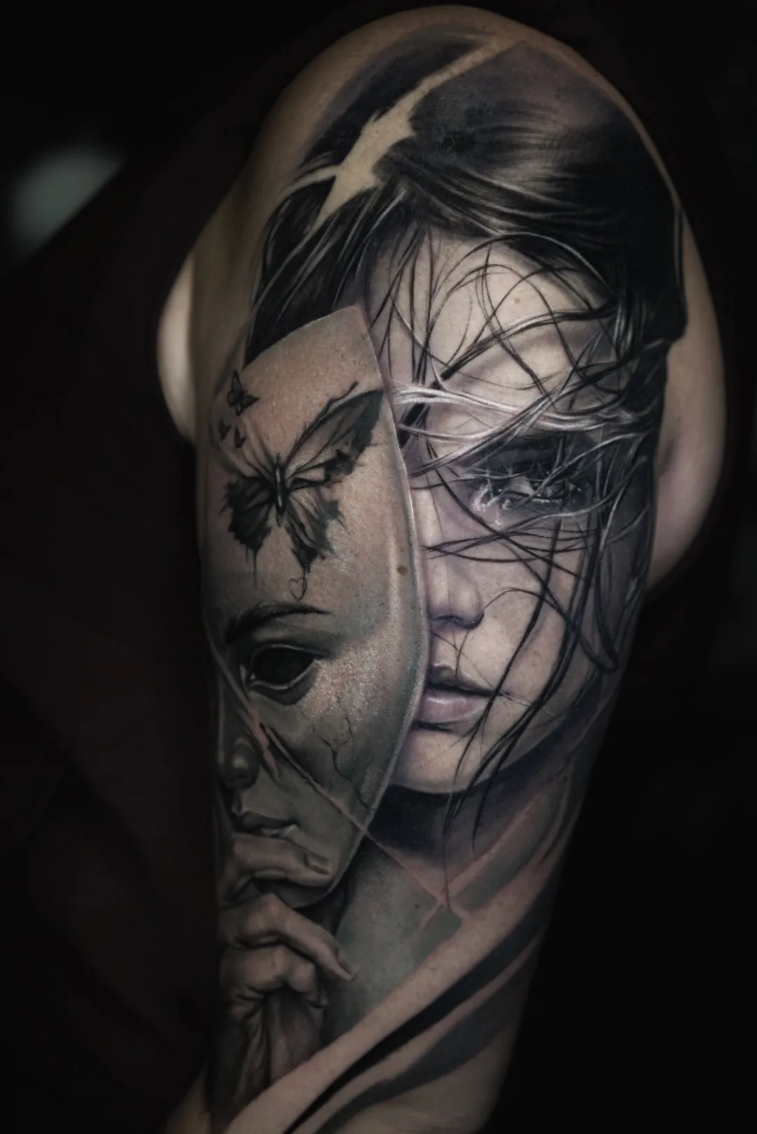 A black and grey portrait of a woman holding a mask decorated with a butterfly.